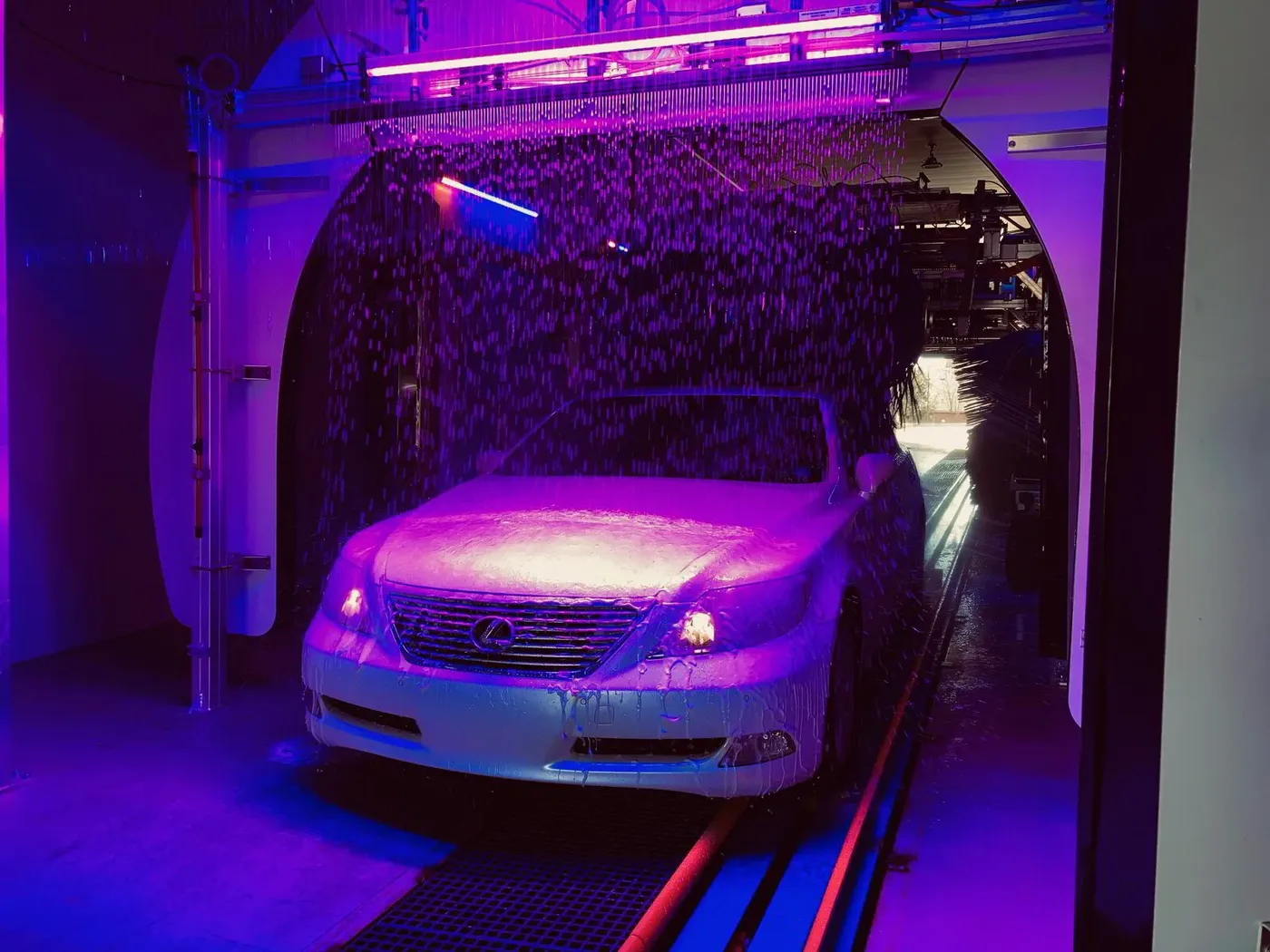A car rolling through the neon-lit Aqua Blue tunnel